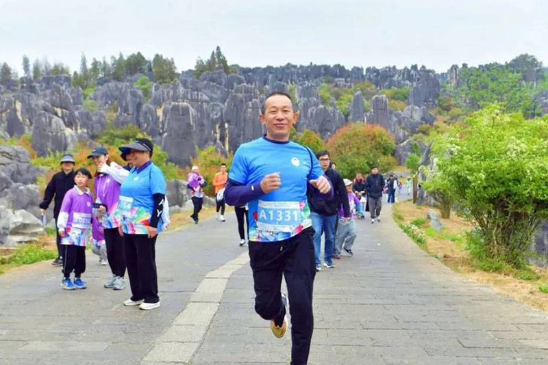 在石林风景区内进行的“穿梭石林奇境”健步走活动和“探秘石林奇境”亲子定向赛上，参与者手持活动打卡地图，穿梭在石峰间，打卡石林胜景、遗产标志石、阿诗玛、火把石等核心地标，用脚步丈量自然奇观，让亲子欢笑融入自然诗意。图片来源：昆明发布